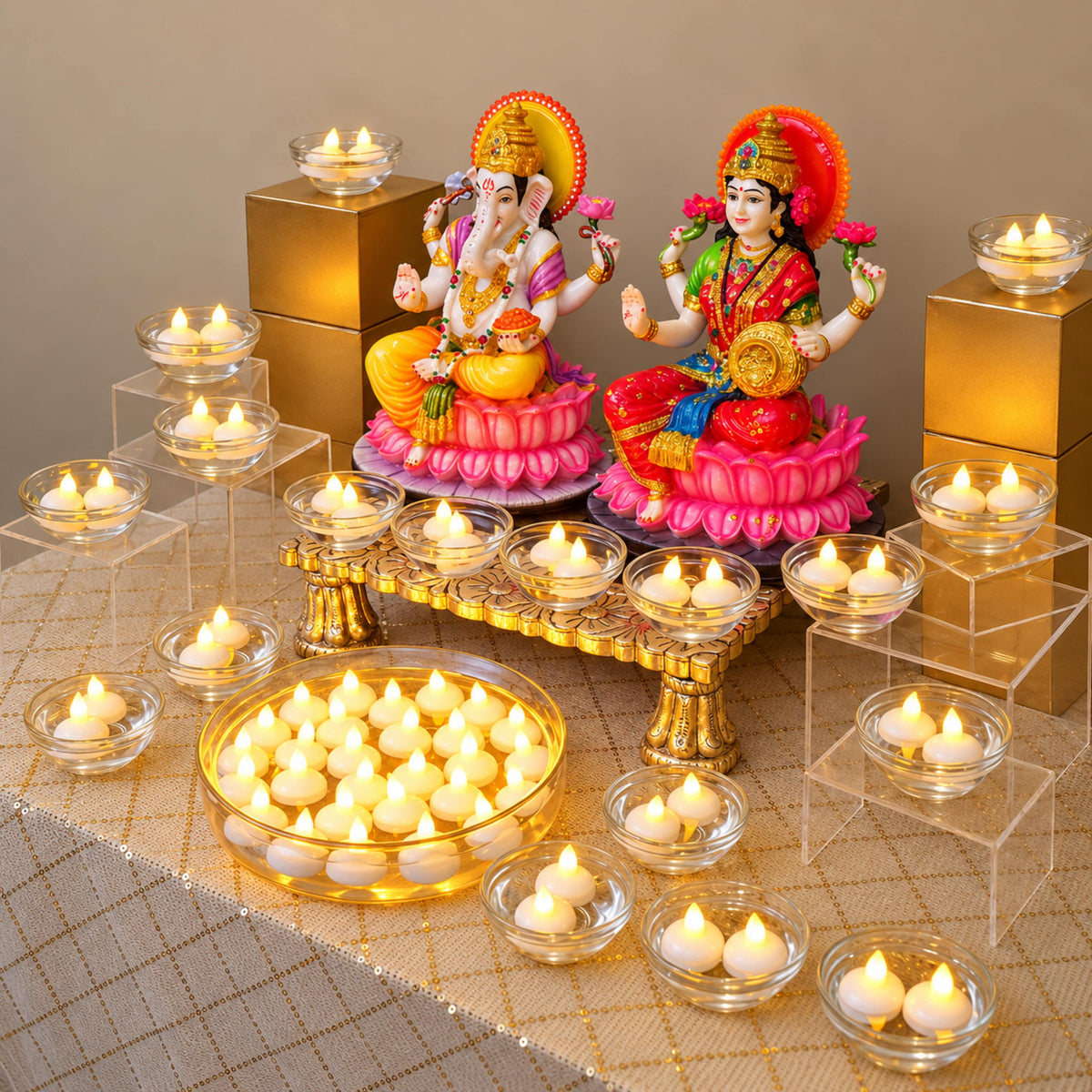 Floating candles crowded close in a wide glass urli with smaller bowls raised on risers around the pooja table