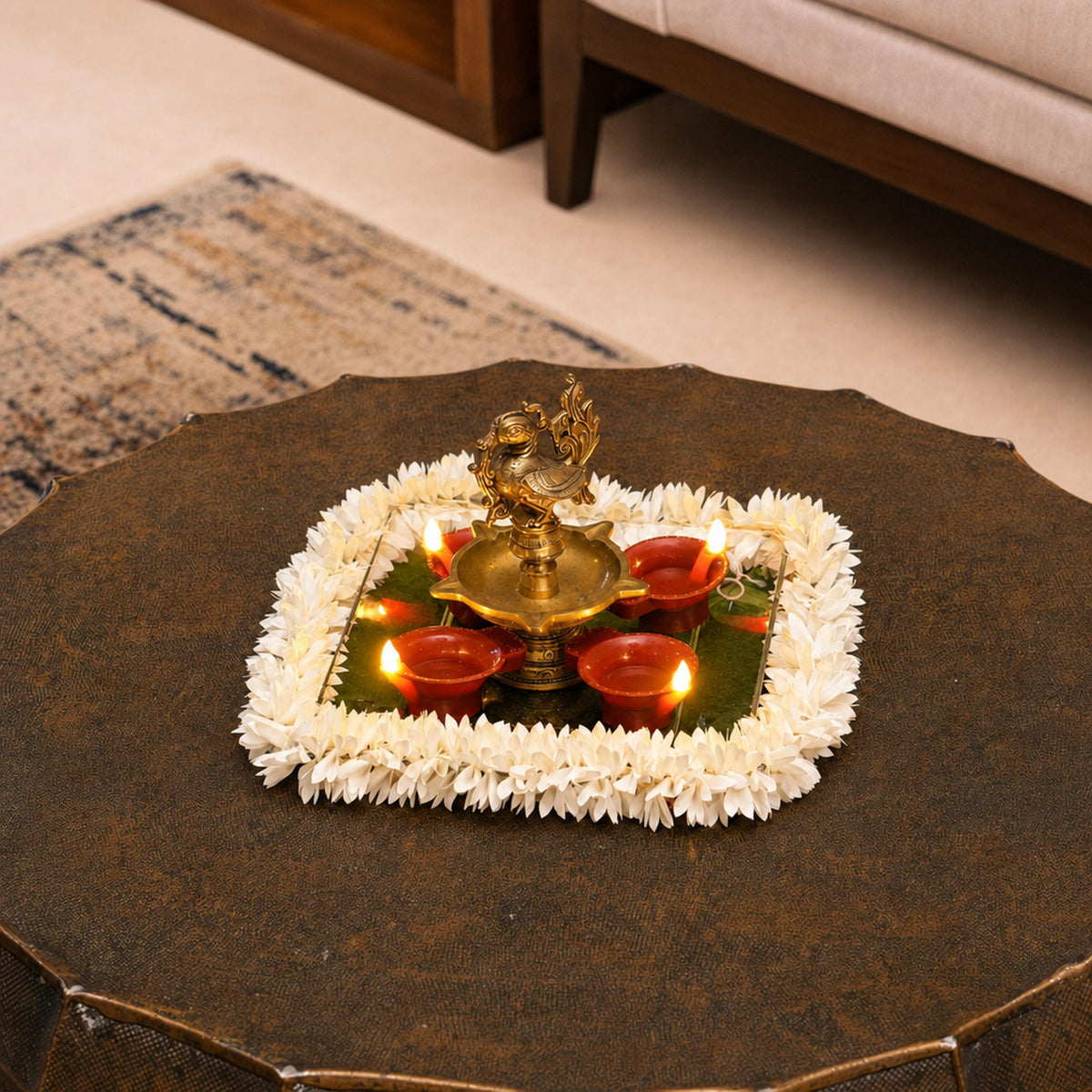 Big flame LED diyas around a brass lamp on a mirrored tray with a flower border