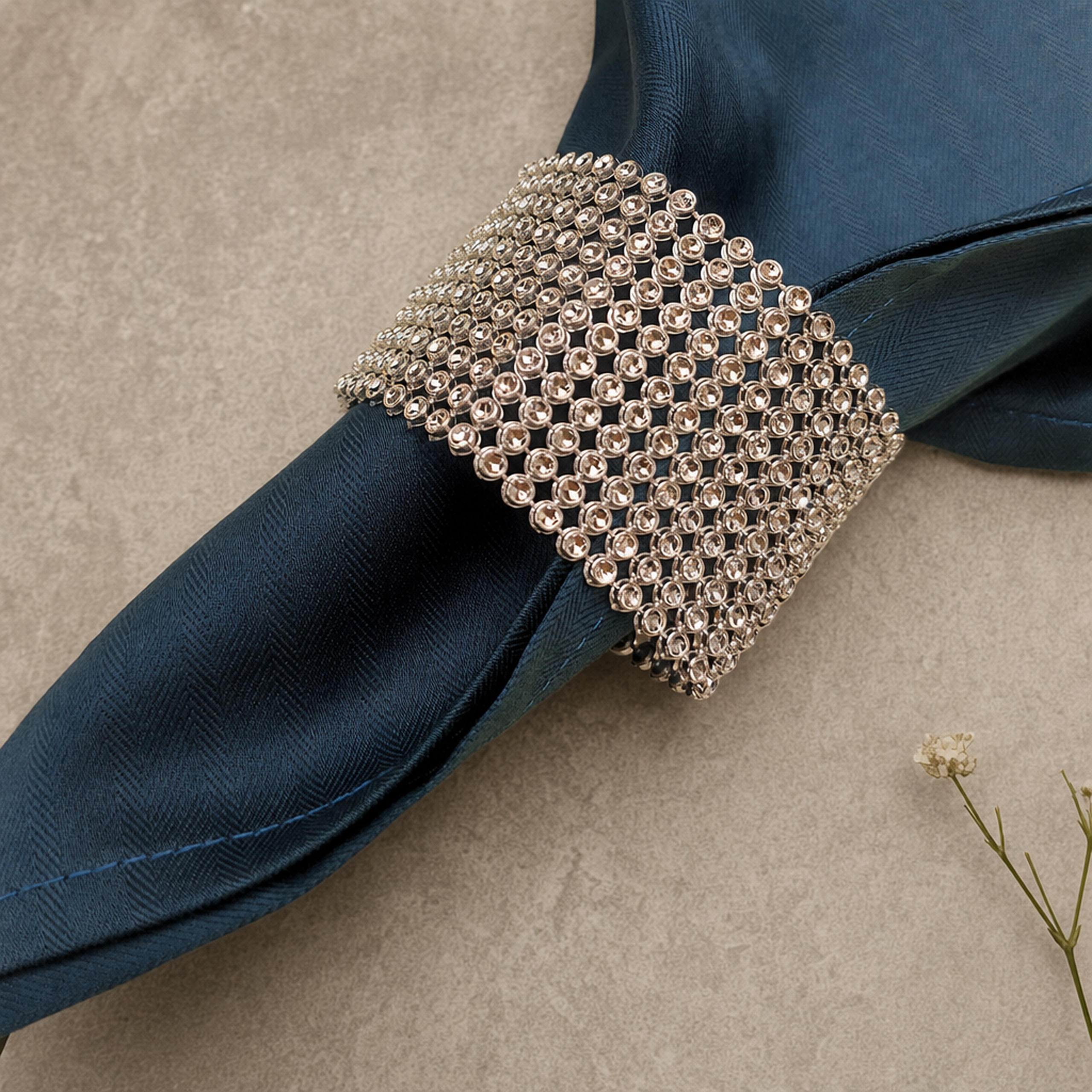 Silver rhinestone napkin ring band on a navy napkin