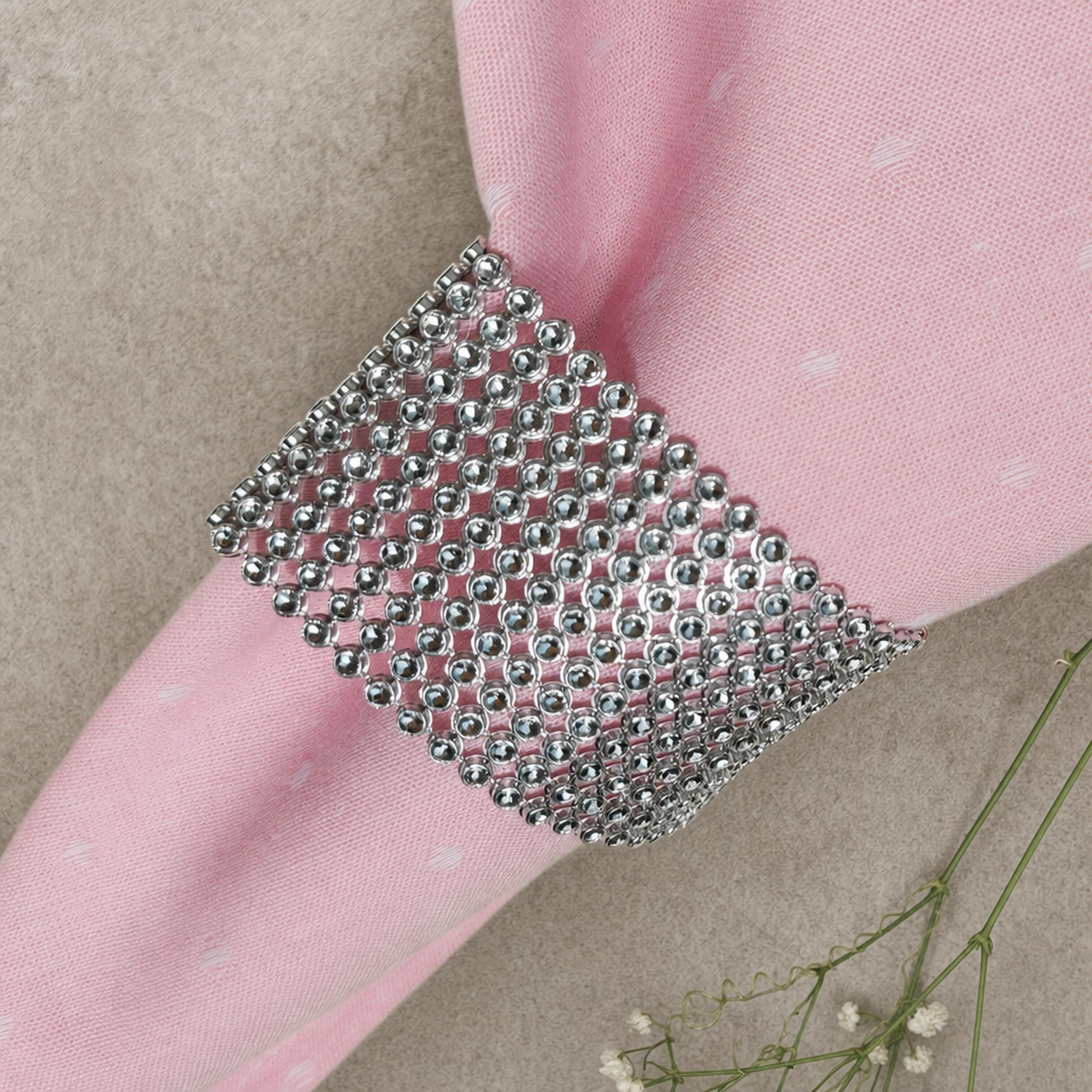 Silver rhinestone napkin ring band on a pink napkin