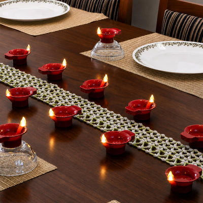 Big flame LED diyas down a dining table along a flower runner