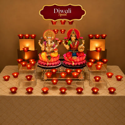 Diwali Special red LED diyas set on risers and across the table around Lakshmi and Ganesh idols