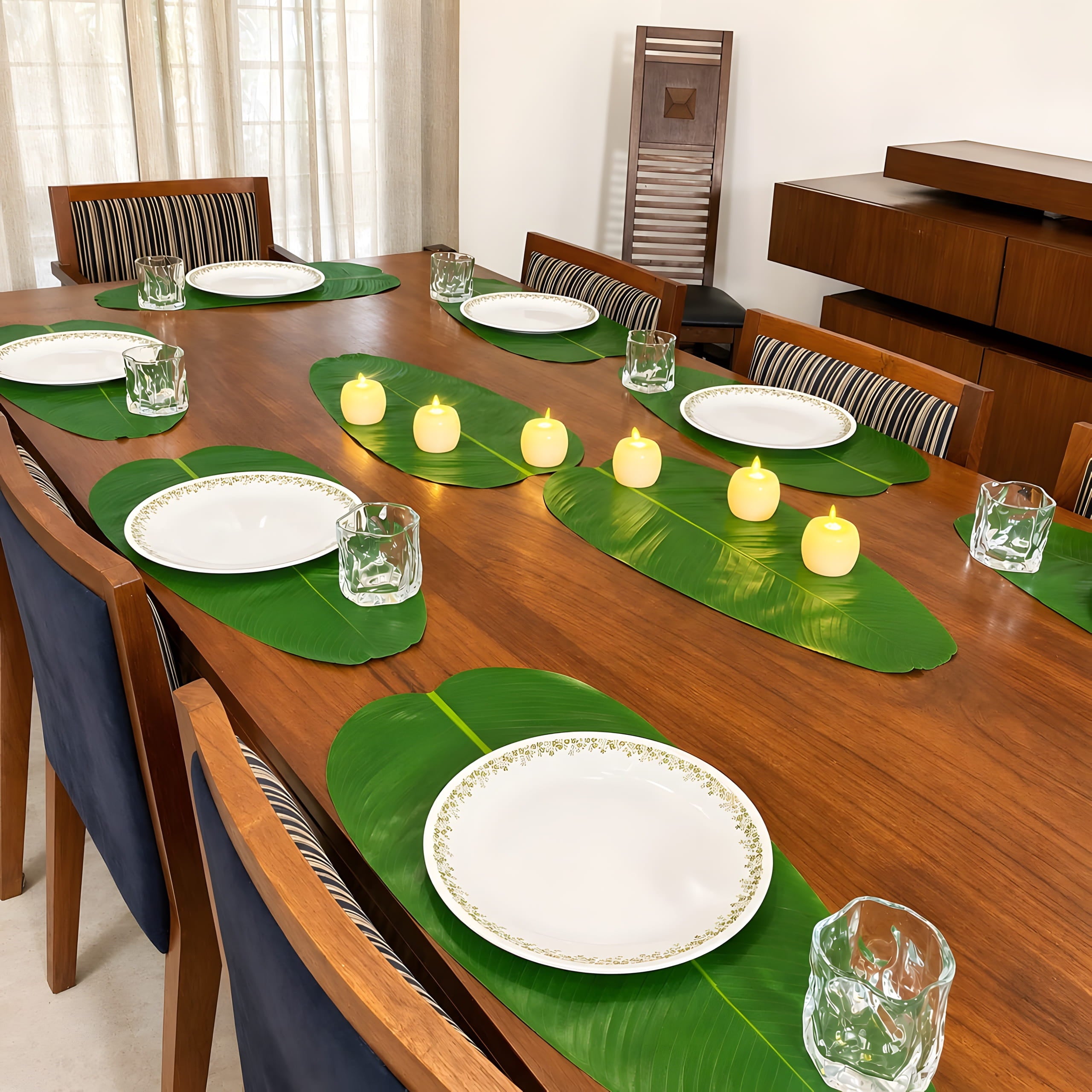 Banana leaf placemats on a dining table with flameless LED candles