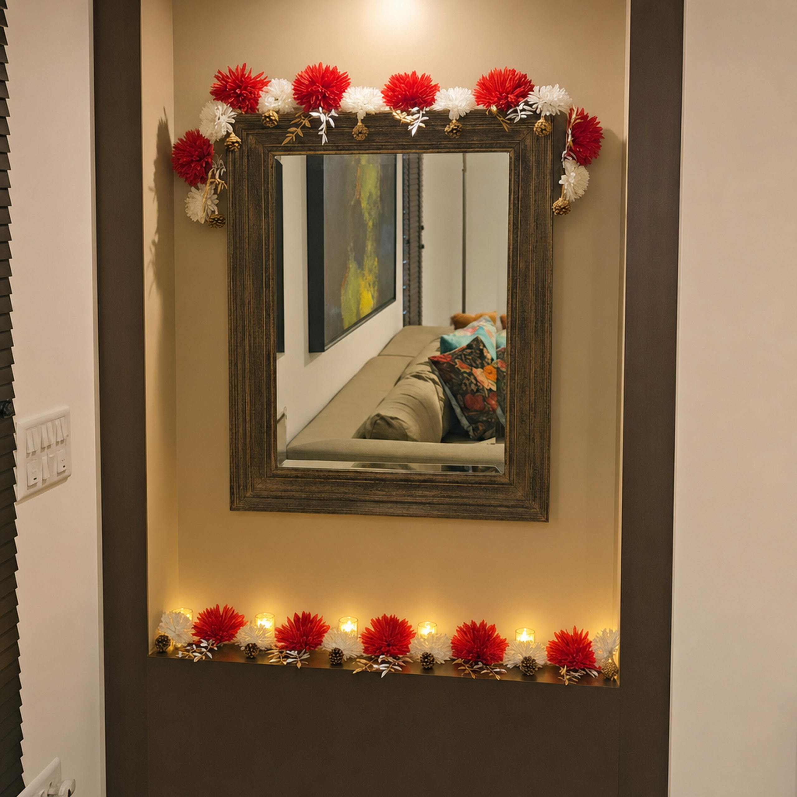Flower toran on a wall above a mirror with decor on the console below