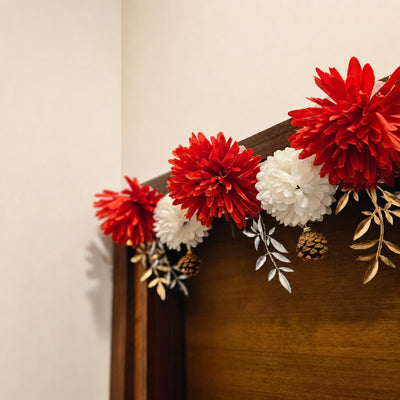 Flower toran draped over a wood console corner against a wall