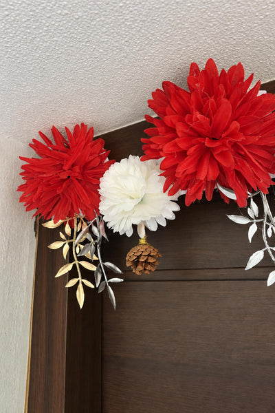 Close-up of the red and white flowers and gold leaves of the toran