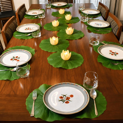 Lotus leaf place mats on a bright dining table setting with LED lotus candles