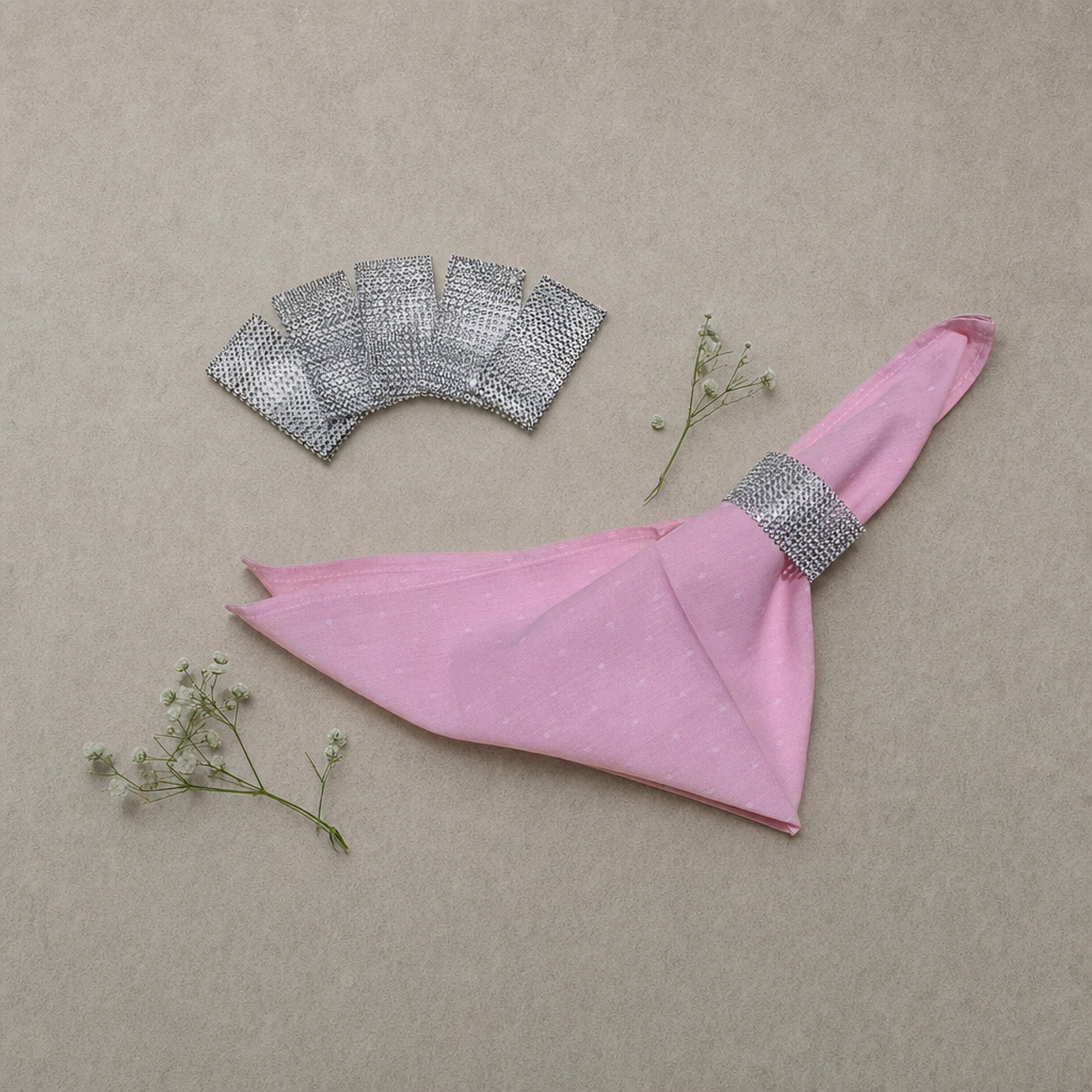Silver rhinestone napkin ring bands flat-lay with a pink napkin