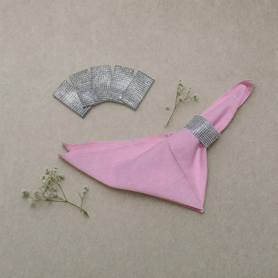 Silver rhinestone napkin ring bands flat-lay with a pink napkin